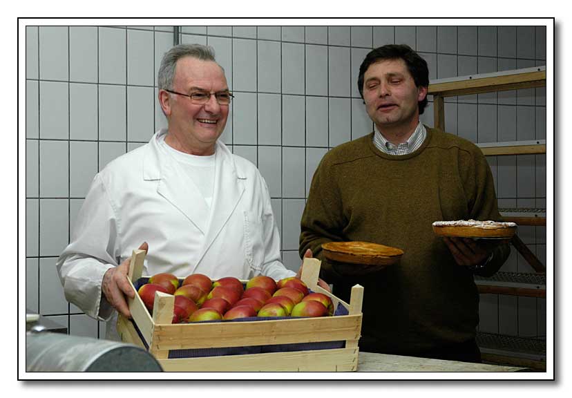 bakker Vanbrabant toont een kist appelen en boer Grammen houdt appelvlaai in zijn handen